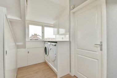 Modern sifon tuvaleti ve seramik lavabo aynanın yanındaki beyaz fayanslı duvarlara ve evdeki küçük tuvaletteki havluya monte edildi.