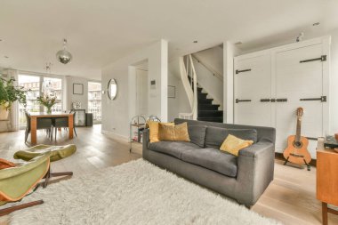 Çağdaş dairenin pencerelerine karşı rahat kanepesi ve televizyonu olan oturma odası.