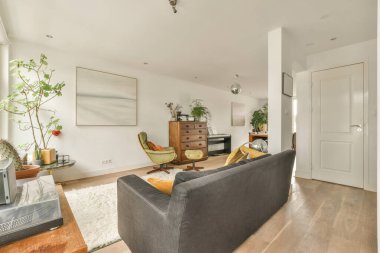 Çağdaş dairenin pencerelerine karşı rahat kanepesi ve televizyonu olan oturma odası.