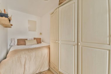 Yatak odasının iç tasarımı, yatak odası ve ahşap gardırop modern dairenin penceresinin kenarına yerleştirilmiş.