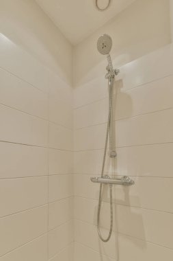 Gri kiremitli duvar ve pencereli pahalı açık banyoda modern duş sütunları