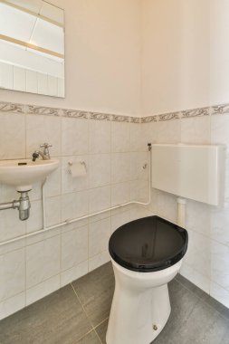 Lavabolu ve duvarlı, beyaz duvarlı ve kareli tuvaletli dar bir tuvalet.