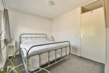 Yatak odasının iç tasarımı, yatak odası ve ahşap gardırop modern dairenin penceresinin kenarına yerleştirilmiş.