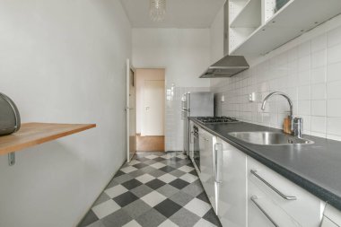 Minimalist tarzı beyaz mobilyalı, lavabolu ve sobalı bir ev mutfağı.