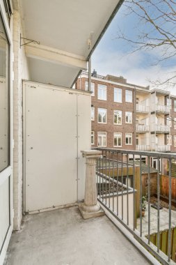 Korkuluklu küçük balkondan eski tuğla binaların önü.