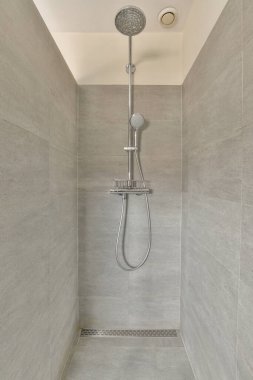 Gri kiremitli duvar ve pencereli pahalı açık banyoda modern duş sütunları