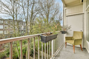 Eski tuğla binaların ve küçük balkondan parmaklıklı bitki örtüsünün önü.