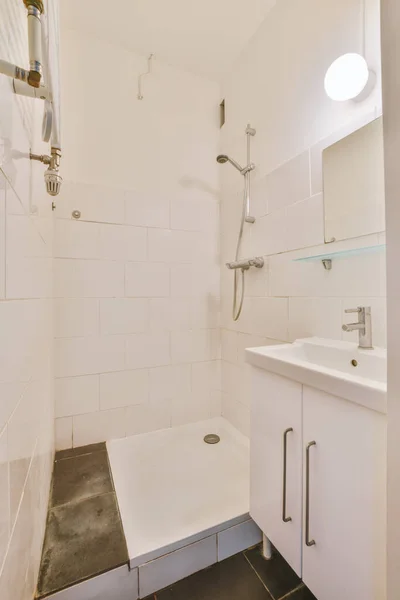 白いタイル張りの壁とモダンなバスルームでガラスドアとミラーとシャワーボックスでシンク — ストック写真