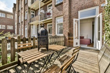 Oturma alanı ve ahşap çitlerin yanındaki küçük bahçesi olan düzgün asfaltlı bir avlu.