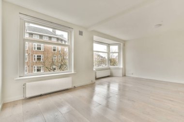 Evdeki boş ışık odasında, beyaz duvardaki plastik pencere ve radyatör.