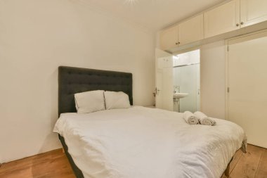 Yatak odasının iç tasarımı, yatak odası ve ahşap gardırop modern dairenin penceresinin kenarına yerleştirilmiş.