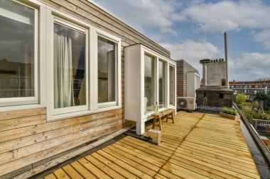 Üçgen şekilli çatısı ve gün ışığında ahşap kirişleri olan açık planlı stüdyo daire.