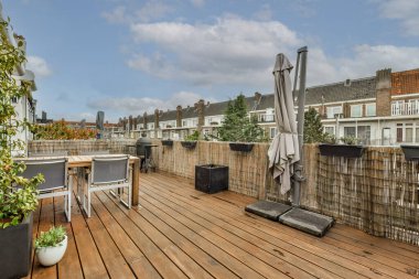 Neat paved patio with sitting area and small garden near wooden fence