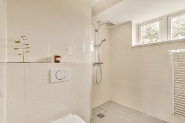 Cam duşlu küvet lavabonun yanında ve aynada beyaz fayans duvarlı küçük bir banyoda.