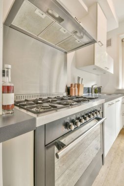 Minimalist tarzı beyaz mobilyalı, lavabolu ve sobalı bir ev mutfağı.