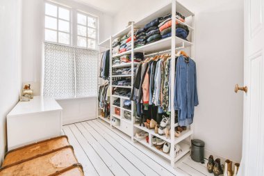 Evdeki aydınlık odada gitar ve dolabın yakınındaki aynalı beyaz gardırop.