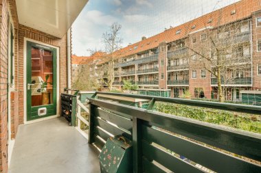 Oturma alanı ve ahşap çitlerin yanındaki küçük bahçesi olan düzgün asfaltlı bir avlu.