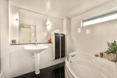 Evdeki modern tuvalette asılı duran banyo musluğu ile duvar arasındaki cam bölme.