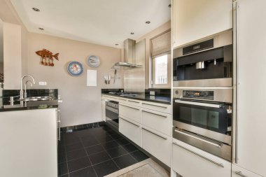 TV 'nin yanındaki koltuklar ve masa, çağdaş apartmandaki geniş odalı yemek alanına karşıdır.