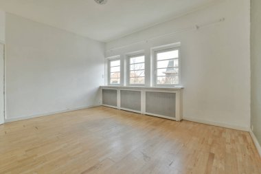 Evdeki boş ışık odasında, beyaz duvardaki plastik pencere ve radyatör.