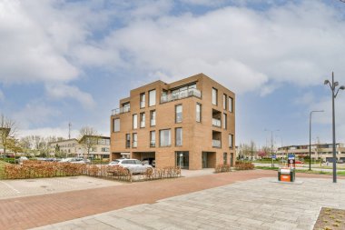 Panorama view of brick house from an empty sidewalk street with cars, trees and lanterns
