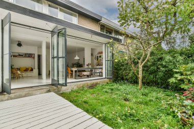 Neat paved patio with sitting area and small garden near wooden fence