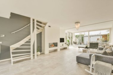 Günümüz minimalist tasarımı. Hafif stüdyo dairesinin ahşap masası ve oturma odası ile beyaz duvarları ve parke zemini arasında yemek masası ve sandalyeleri var.