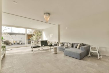 Günümüz minimalist tasarımı. Hafif stüdyo dairesinin ahşap masası ve oturma odası ile beyaz duvarları ve parke zemini arasında yemek masası ve sandalyeleri var.