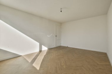 Evdeki boş ışık odasında, beyaz duvardaki plastik pencere ve radyatör.