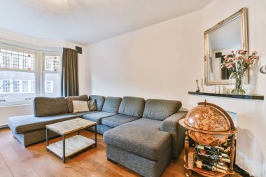 Yumuşak yastıklı rahat bir kanepe şık bir avizenin altında kemerli, ferah bir oturma odasında.