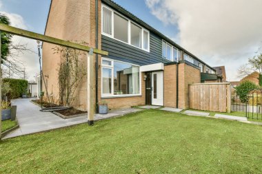 Levhalı, kaldırımlı ve ahşap kapılı bir binanın ön manzarası daireye çıkıyor.