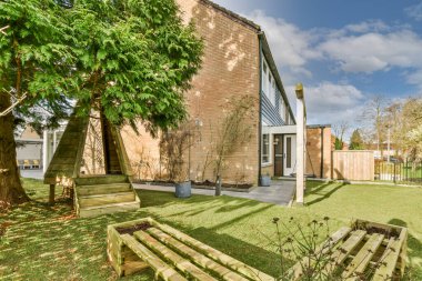 Oturma alanı ve ahşap çitlerin yanındaki küçük bahçesi olan düzgün asfaltlı bir avlu.