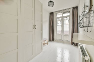 Evdeki boş ışık odasında, beyaz duvardaki plastik pencere ve radyatör.