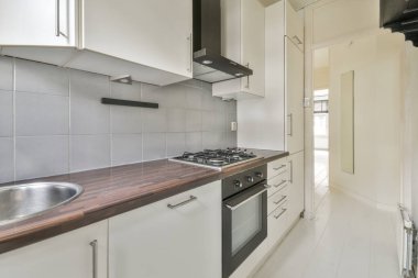 Interior of empty white kitchen with corridor and wooden parquet floor