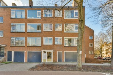 Ağaçlar ve fenerlerle dolu boş bir kaldırım sokağından tuğla evler manzarası