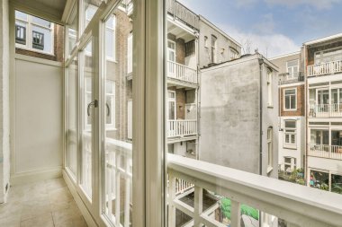 Korkuluklu küçük balkondan eski tuğla binaların önü.