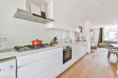 Minimalist tarzı beyaz mobilyalı, lavabolu ve sobalı bir ev mutfağı.