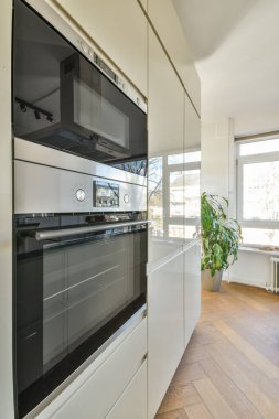 Minimalist tarzı beyaz mobilyalı, lavabolu ve sobalı bir ev mutfağı.