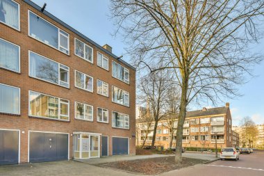 Ağaçlar ve fenerlerle dolu boş bir kaldırım sokağından tuğla evler manzarası