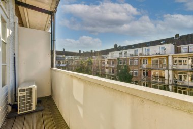 Eski tuğla binaların panoramik manzarası. Küçük balkondan park yerleri ve ağaçlar.