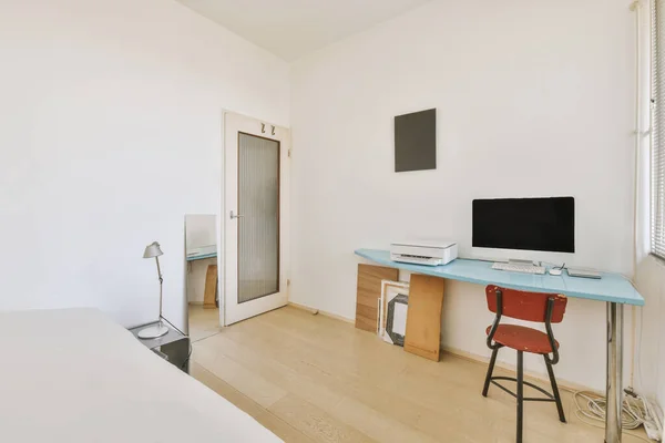 現代のフラットの光の家のオフィスで空白のホワイトボードやミラーに対するコンピュータモニタとテーブルの近くに配置快適な椅子 — ストック写真