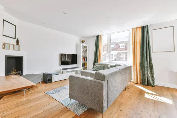 Günümüz minimalist tasarımı. Hafif stüdyo dairesinin ahşap masası ve oturma odası ile beyaz duvarları ve parke zemini arasında yemek masası ve sandalyeleri var.