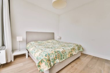 Yatak odasının iç tasarımı, yatak odası ve ahşap gardırop modern dairenin penceresinin kenarına yerleştirilmiş.