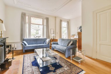 Geniş pencereli, ahşap kanepeli, dolaplı ve televizyonlu modern minimalist oturma odasının iç tasarımı beyaz duvara yerleştirilmiş.