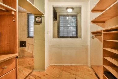 Çağdaş dairenin geniş odasındaki dinlenme odası ve mutfağın yakınındaki sandalyeli ve çiçekli masa.