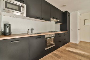 Minimalist stil mutfak, basit dolaplar ve aydınlık dairede modern aletler.