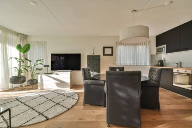 Çağdaş dairenin şık oturma odasındaki kanepe ve televizyonun yanına yerleştirilmiş kare masa.