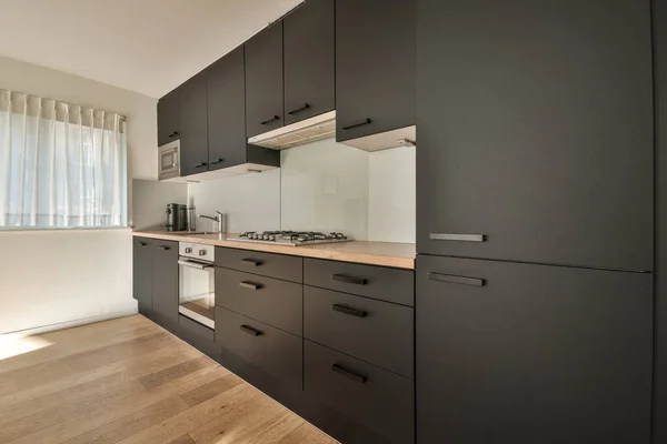 简约风格厨房的内饰 简朴的橱柜和轻便公寓的现代器具 — 图库照片
