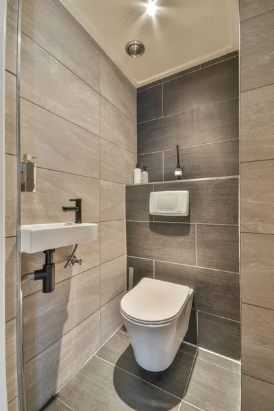 Interior of contemporary bathroom with shabby beige walls and partitions and white door at home