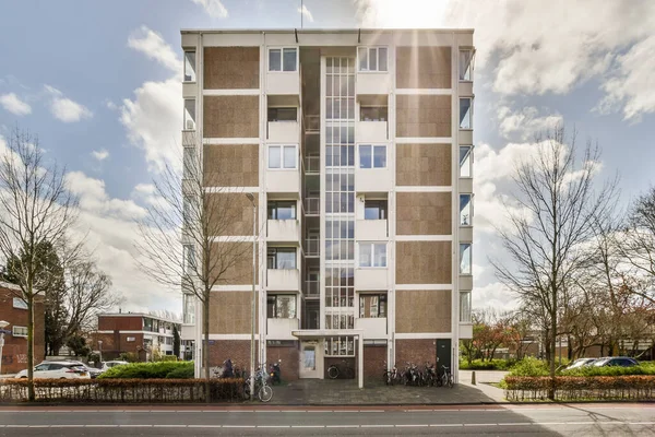 Arabaları, ağaçları ve fenerleri olan boş bir kaldırımdan panorama manzaralı evler.